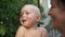 Close portrait of smiling grandmother and grandson. Mature woman holds one year old baby in her arms, vacation in the