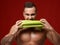 Close portrait of strong muscular athlete men bite fresh celery