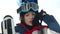 Close portrait. Teen boy in a helmet and goggles rises up in a ski lift cabin. The child laughs happily. Fun holidays in