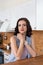 Close portrait of a young attractive elegant smiling woman in the kitchen behind the counter