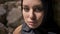 Close portrait of young muslim woman in black hijab looking at camera, standing near brick wall, beautiful charming eyes