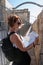 Close portrait of young woman looking at map and pointing to direction at Jaffa Gate walls in Jerusalem