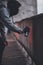 Close shoot of Young anonymous graffitist making protest graffiti with red paint