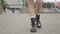 Close shot of female legs walking in heavy armi boots. Closeup shooting fashionable female in leather boots walk in