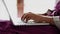 A close shot at the hands of a woman who quickly prints text on the laptop keyboard, the ladies are working in the