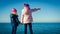 Close shot image of two kids standing on sea shore, holding hands