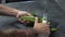 Close shot of male hands with tattoos peeling fresh cucumber with long knife