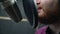 Close shot of man with red beard face, fast broadcast text with microphone