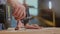 Close shot of man screwing a screw in a wood board using electrical screwdriver