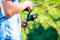 Close shot of sport fisherman reeling in line on fishing rod