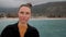 Close shot of woman face on shore of lake, looking into camera