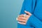 Close shot of a woman\'s hand in a blue knitted sweater