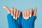 Close shot of a woman\'s hand in a blue knitted sweater