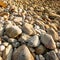 Close of stone beach at sunset, beautiful shape and patterns of stones and pebbles on natural tropical beach. Lanta Island,