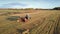 Close tractor drives baler pushes up straw bale on field