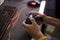 Close uo of hands playing videogames holding a controller - modern technology hobby and entertainment for all people - indoor at