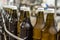 Close-up of 0.5-liter brown glass bottles of water on a conveyor belt