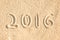 Close up on 2016 written in the sand