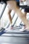 Close Up Of 3 Runners Feet On Running Machine In Gym