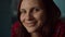 Close up of 30s female adult in casual clothes smiling looking at camera in slow motion. Woman portrait at home.