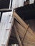 Close up of an abandoned collapsing wooden building made of brown timber with scattered planks and door