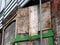 Close up of an abandoned derelict old house with crumbling brick walls and blocked up windows