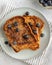 Close-up from above of three slices of french toast with blueberries on a plate on grey background, minimalistic style