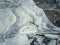 Close up abstract background of a frozen puddle. Cracked pothole ice texture, winter season pattern