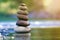 Close-up abstract image of wet rough natural brown uneven different sizes and forms stones balanced like pyramid pile landmark in