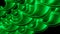 Close up of abstract plastic green springs stretching isolated on a black background. Design. Spiral shaped long wavy