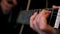 Close up of acoustic guitar with black neck and steel strings in musician hands during rock ballads concert. Concept