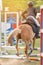 Close up action equestrian rider horse jumping over hurdle obstacle