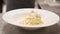 Close-up of adding parmesan in carbonara spaghetti in a plate ready to serve