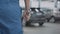 Close-up of adjustable wrench in hand of Caucasian man walking in slowmo to broken car. Unrecognizable repairman