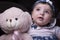 Close up of an adorable drooling baby, with pink teddy