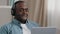 Close-up adult african american man in headphones communicating on webcam on laptop using video calling app hotline