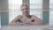 Close-up of adult Caucasian lady resting at poolside and looking around. Portrait of blond charming woman in blue