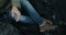 Close-up aerial view of the male feet in boots on black volcanic beach in Iceland. Cameraman catching copter in hand.