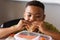 Close-up of african american elementary schoolboy eating sandwich at desk during lunch break