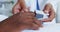 Close-up of African american female doctor attaching pulse oximetry on male patient hand in the ward