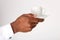 Close up african american male hand holding cup of coffee with saucer