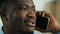 Close up african american man talking phone indoors ethnic smiling male 30s businessman speak with mobile smartphone