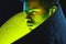 Close up African-American man in yellow glow on dark background in neon light.