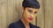 Close up of African woman in black dress and red lipstick leaning against wall