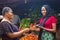 Close up of an african woman selling food stuff in a local african market holding a mobile point of sale device collecting a