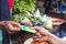 Close up of an african woman selling in a local african market holding a mobile point of sale device collecting a credit card from