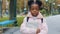 Close-up afro child standing with book in hand in park schoolgirl seriously looking at camera portrait african american