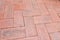 Close-up of an aged brick paved courtyard, a pattern of clay brick lay to for pattern zigzag style