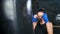 Close-up aggressive female mma fighter hitting punching bag during boxing training at gym