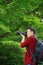 Close up Aisan Chinese man photographer hold camera work in nature shot maple